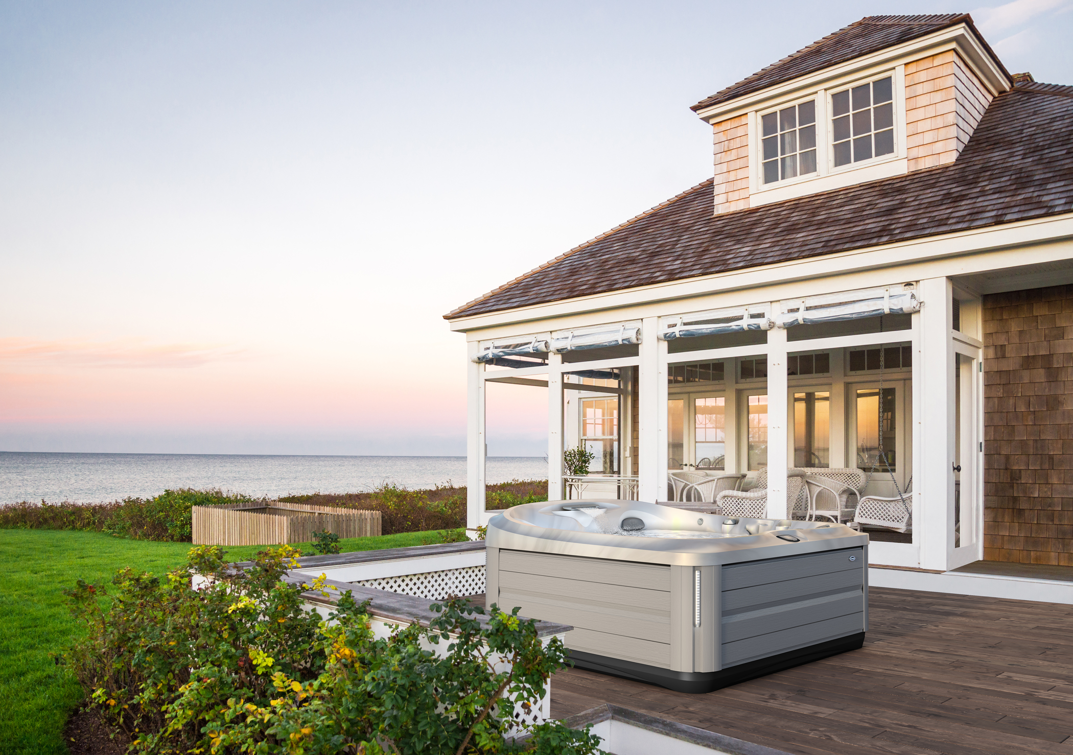 Jacuzzi Hot Tub installed on a deck outside of a modern home by the water.