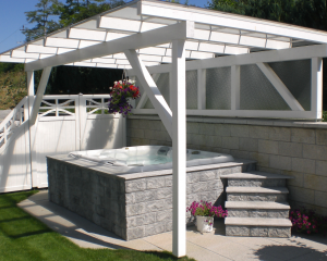 Outdoor hot tub installed underneath a white pergola.