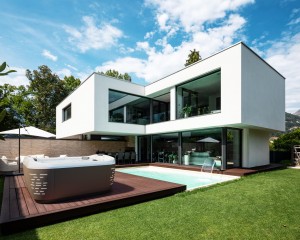 Hot tub installed on a deck behind a modern home.