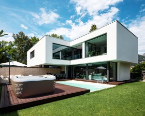 Hot tub installed on a deck behind a modern home.